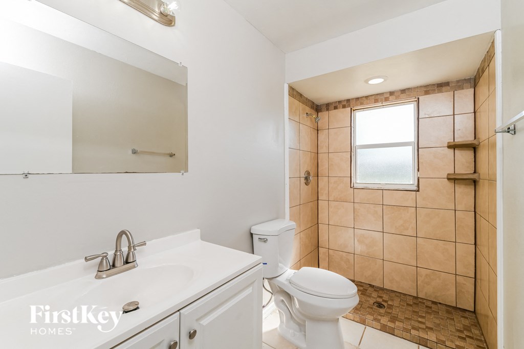 a bathroom with a toilet and a sink and a shower