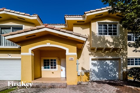 A yellow house with a garage door and a window.