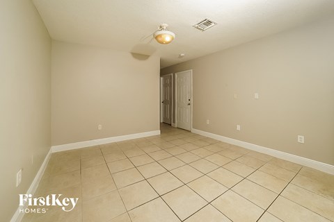 A spacious empty room with a doorway leading to another room.