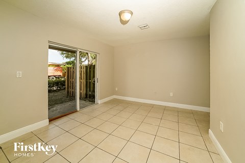 A room with a tiled floor and a sliding glass door leading outside.