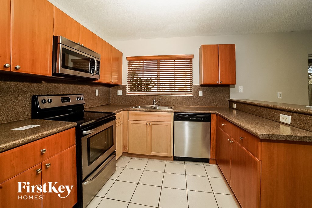 A kitchen with wooden cabinets and a stainless steel dishwasher.