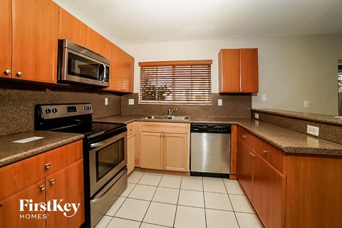 A kitchen with wooden cabinets and a stainless steel dishwasher.