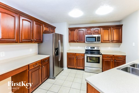 A kitchen with wooden cabinets and a stainless steel refrigerator.