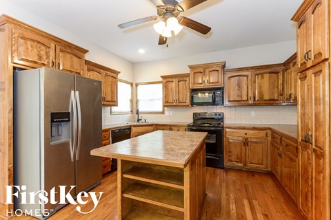 A kitchen with wooden cabinets and a stainless steel refrigerator.