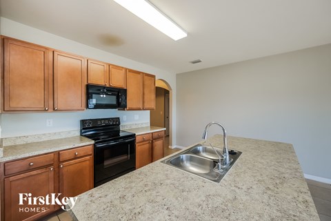a kitchen with granite counter tops and wooden cabinets