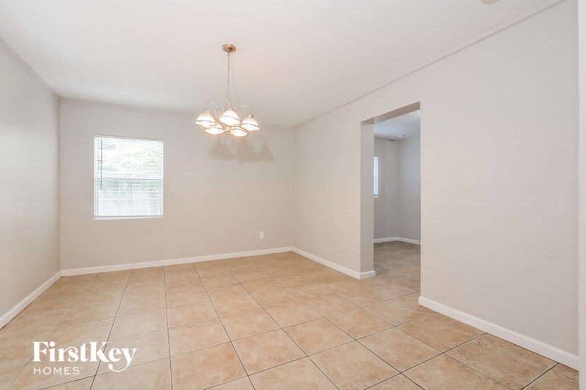 a dining room with tile flooring and a door to a hallway