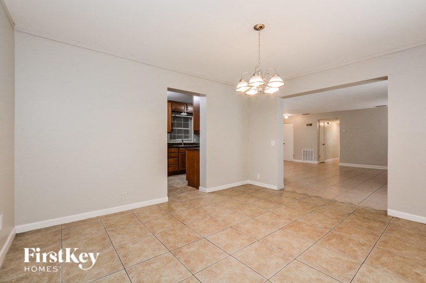 a kitchen and living room with tile flooring and a chandelier