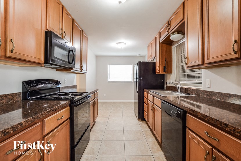 a kitchen with black appliances and wooden cabinets