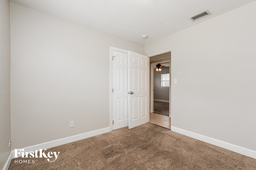 a bedroom with a closet and a door to a hallway