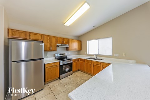 A kitchen with a stainless steel refrigerator and wooden cabinets.