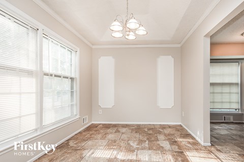 A room with a tiled floor and a chandelier hanging from the ceiling.
