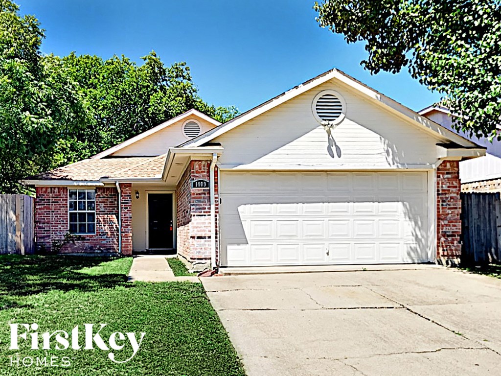 A house with a white garage door and a brick wall.