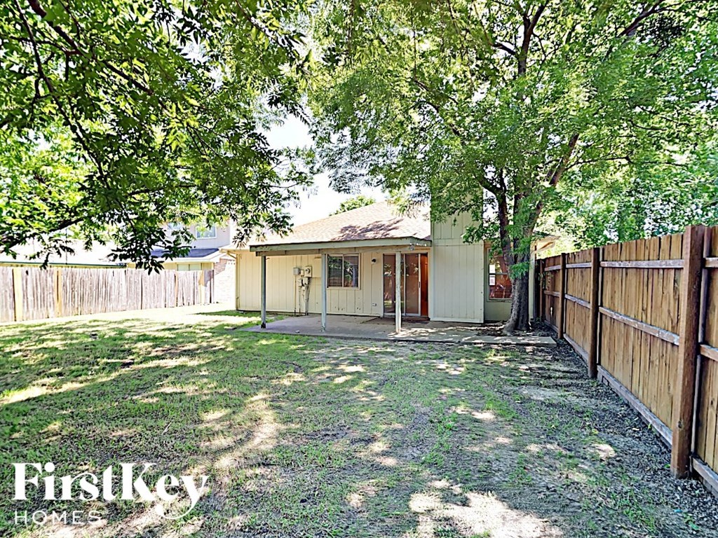 A house is for sale in a sunny backyard.