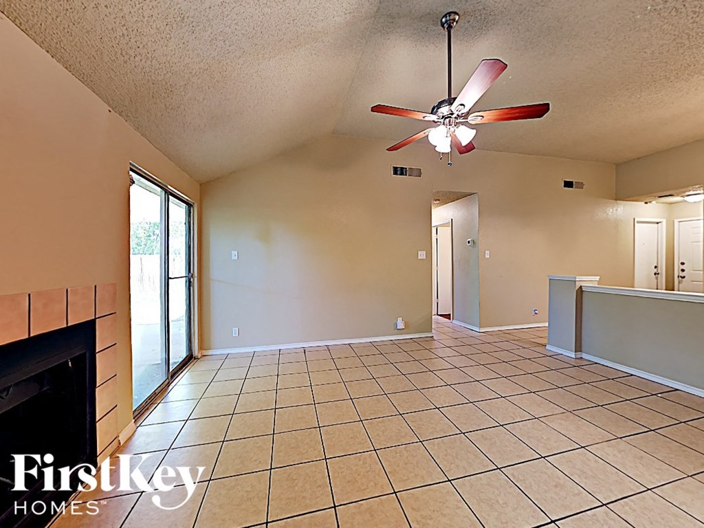 A spacious room with a fan and tiled flooring.