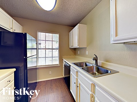 A kitchen with a sink and a refrigerator.