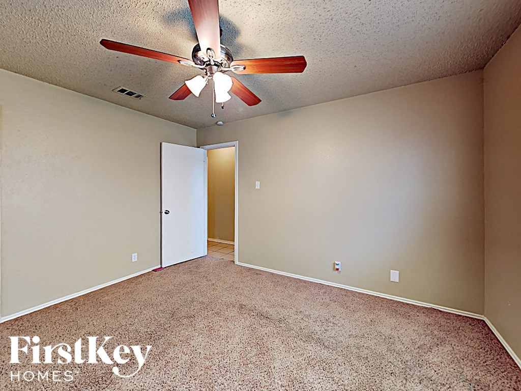 A room with a ceiling fan and a carpeted floor.