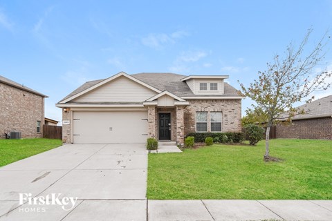 a white and brick house with a yard and a driveway