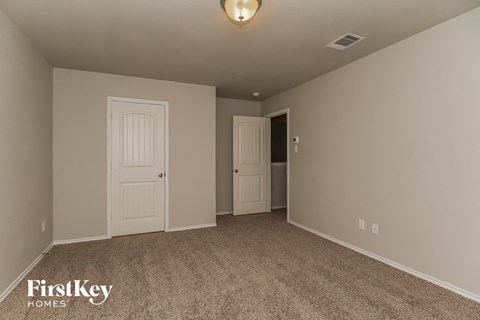 a bedroom with a carpeted floor and a white door