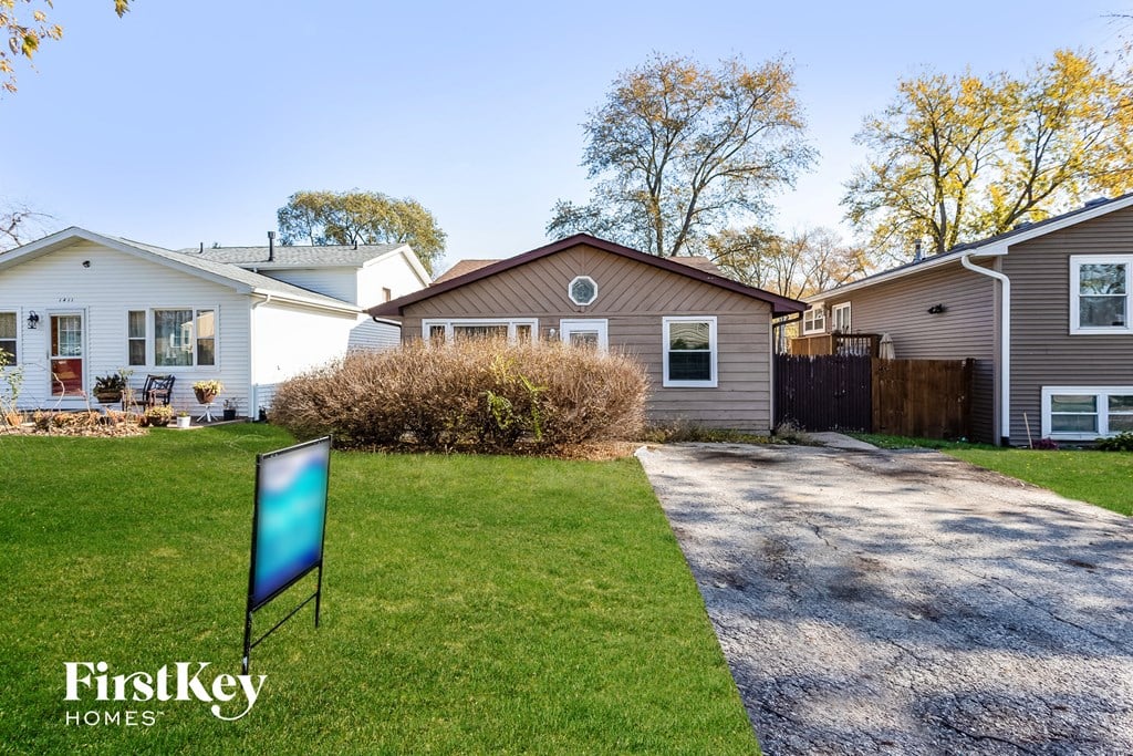 A sign for FirstKey Homes is in the foreground of a residential street.