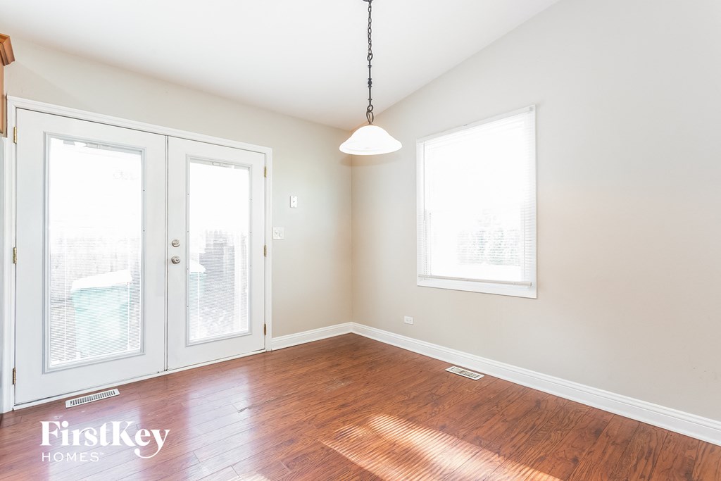 A room with wooden floors and a hanging light fixture.