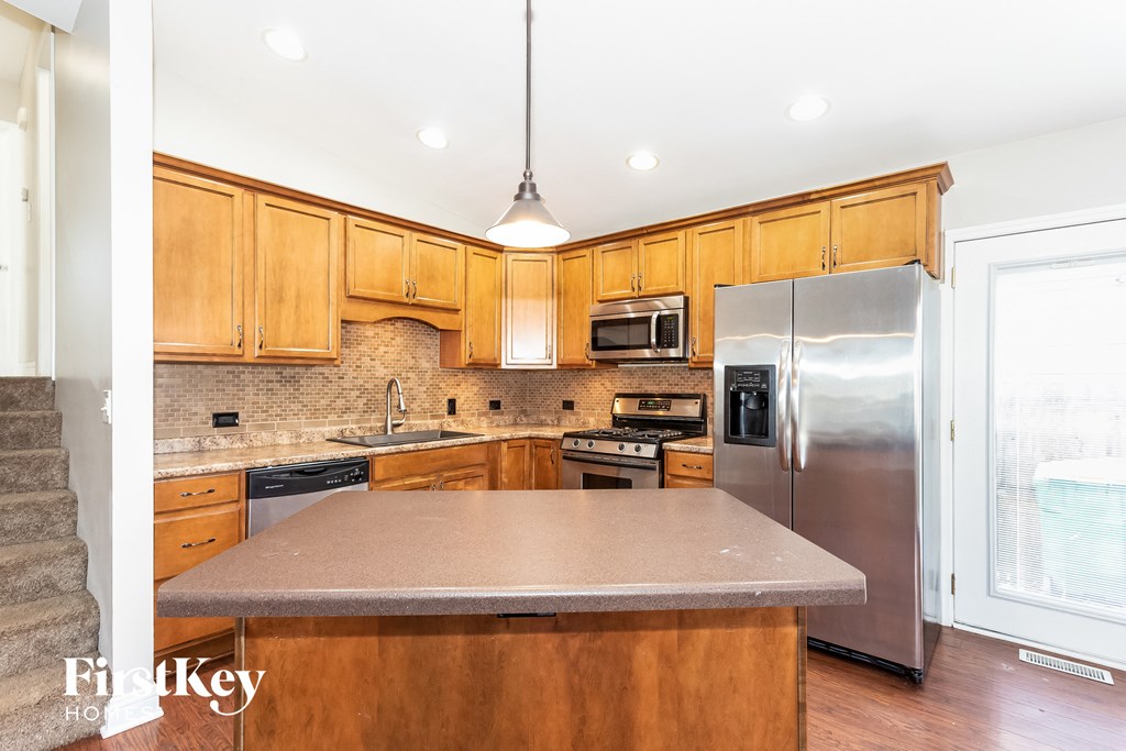 A kitchen with wooden cabinets and stainless steel appliances.