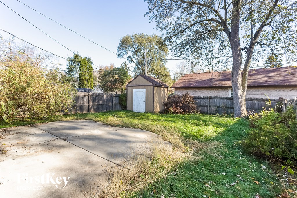 A small white door is on a building in a backyard.