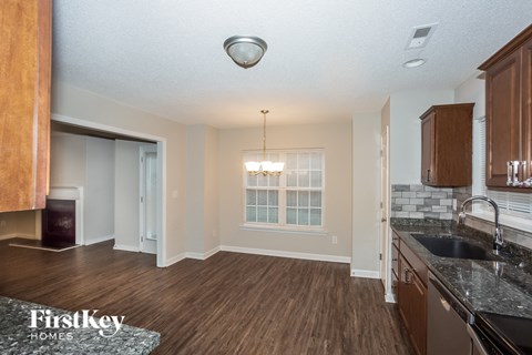A kitchen with wooden floors and a black counter top.