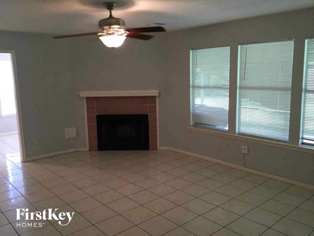 a living room with a fireplace and a ceiling fan