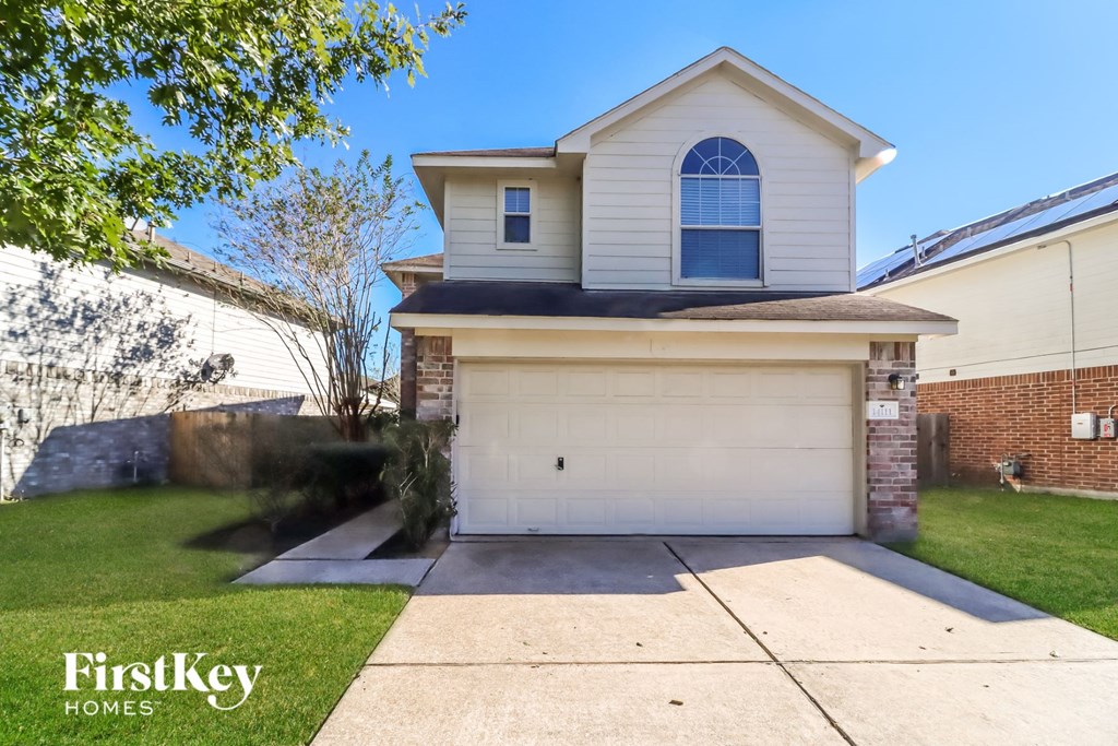 a white house with a white garage door and a lawn