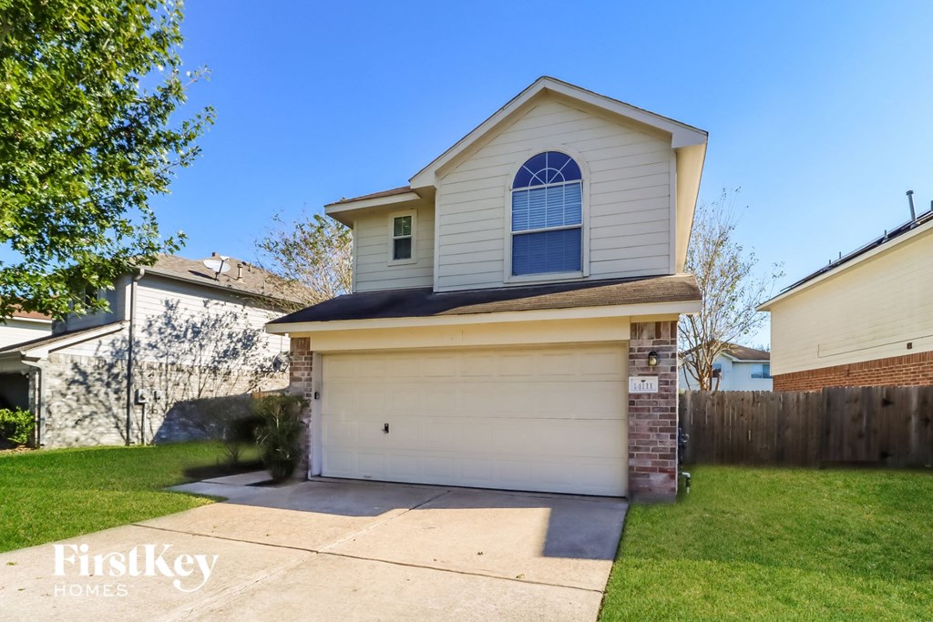 the front of a white house with a white garage door