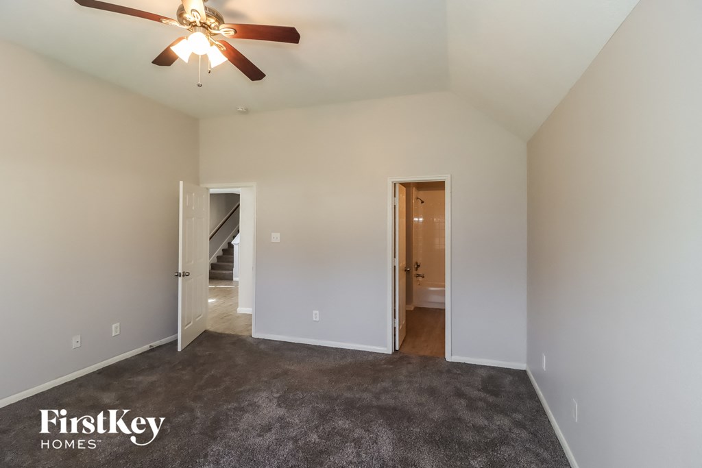 an empty living room with carpet and a ceiling fan
