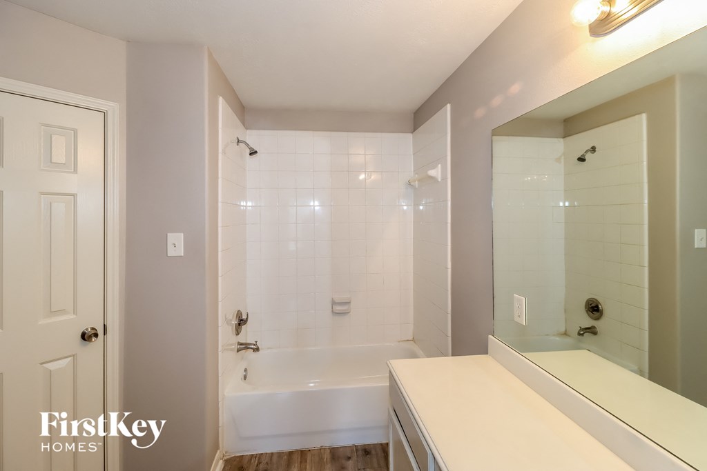 a bathroom with a tub and a sink and a mirror