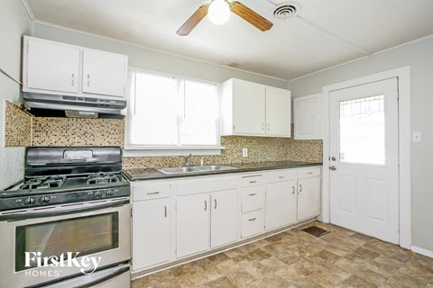the kitchen has stainless steel appliances and white cabinets
