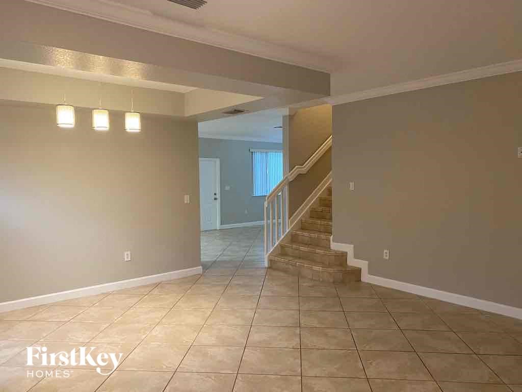 A spacious room with a staircase leading to another room.