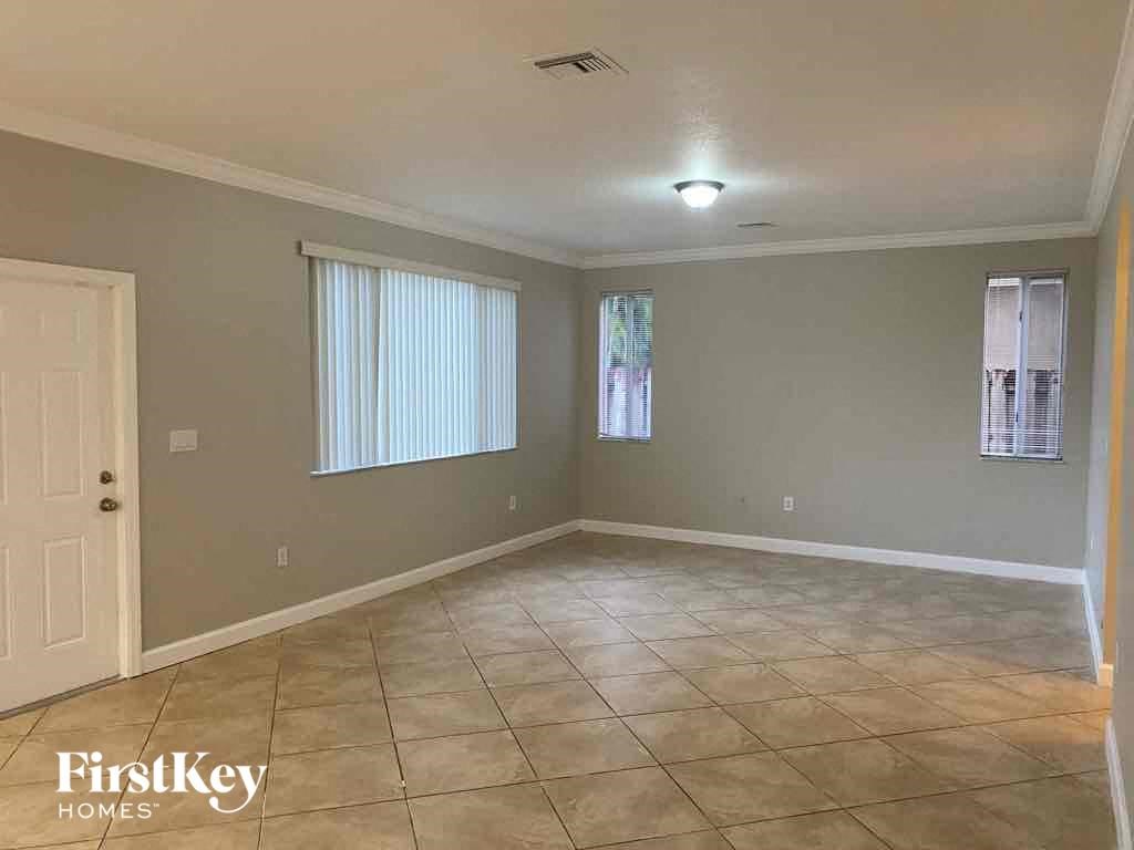 A spacious room with tile flooring and a ceiling light fixture.