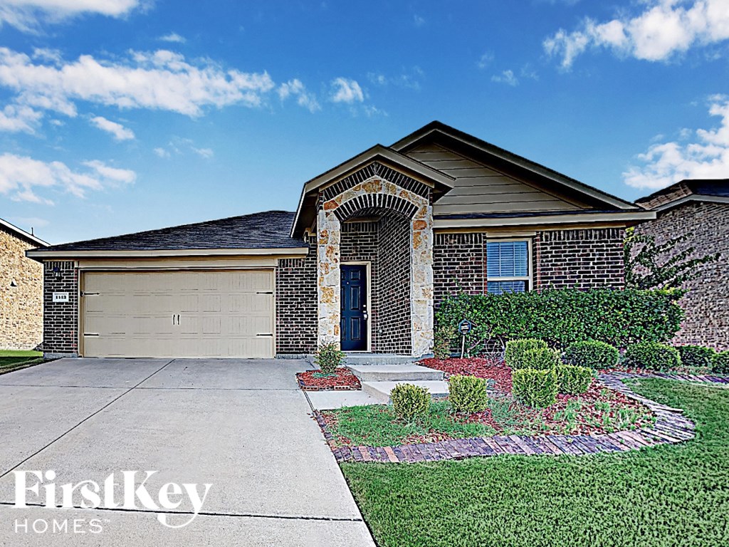 A house with a garage and a brick wall.