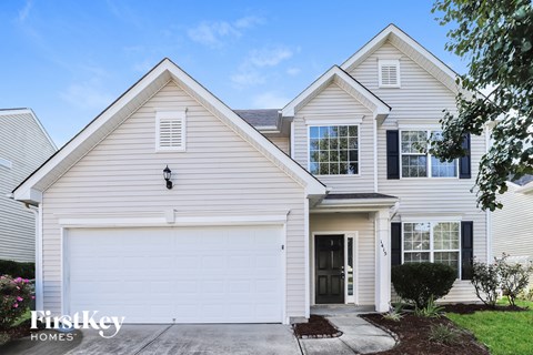 A two-story house with a garage and a driveway.