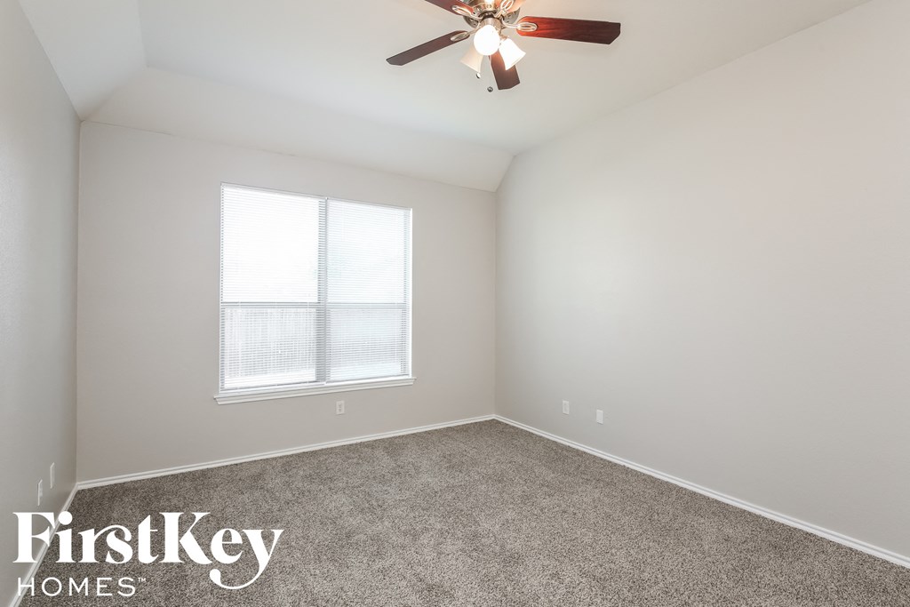 a bedroom with a ceiling fan and a window