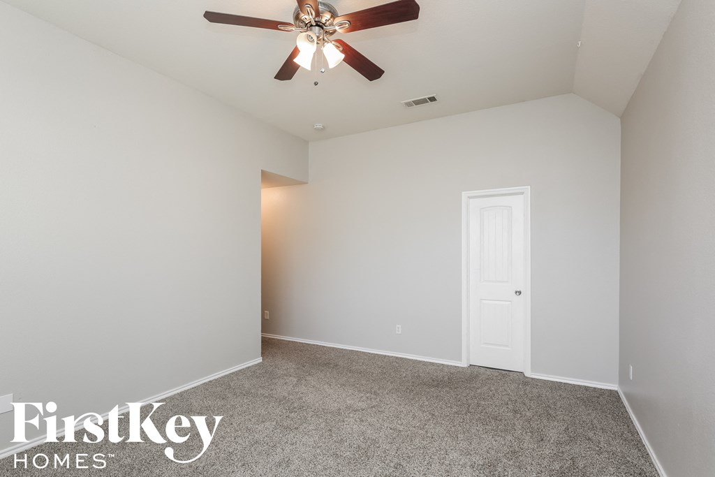 the master bedroom has a ceiling fan and a carpeted floor