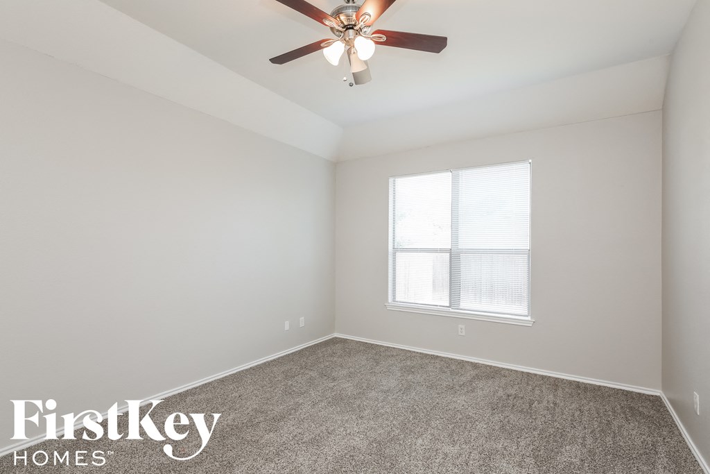 a bedroom with a ceiling fan and a window