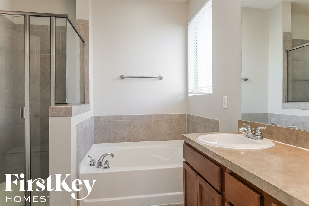 a bathroom with a sink and a tub and a shower