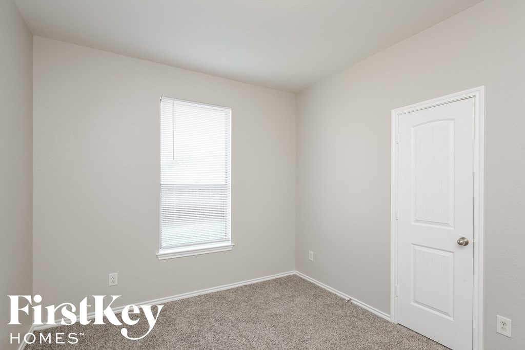 a bedroom with a white door and a window
