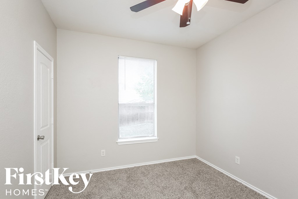 a bedroom with a ceiling fan and a window