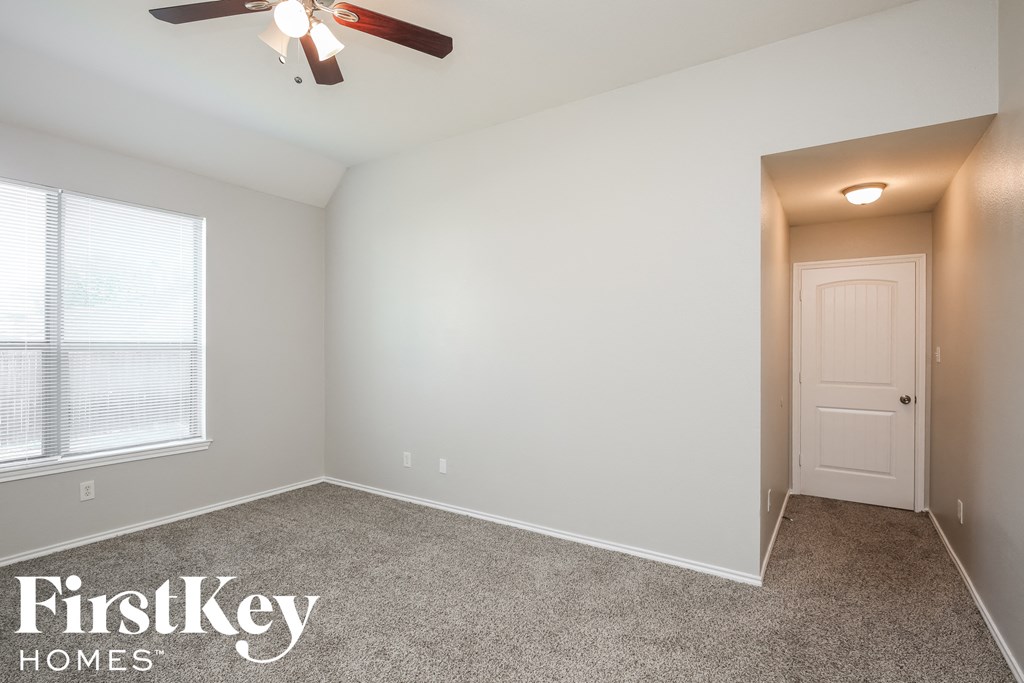 a bedroom with a ceiling fan and a white door