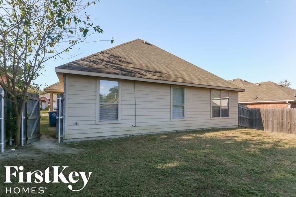 the front of a house with a yard and a fence