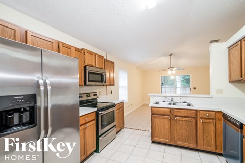 A kitchen with a stainless steel refrigerator and wooden cabinets.