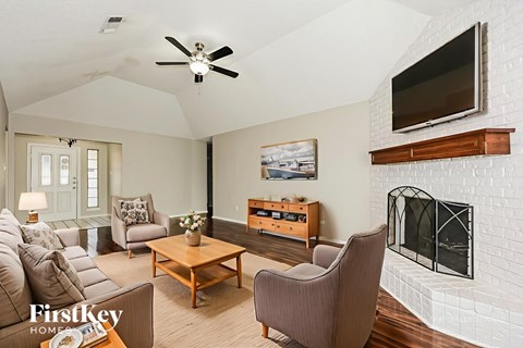 A living room with a fireplace and a television mounted on the wall.