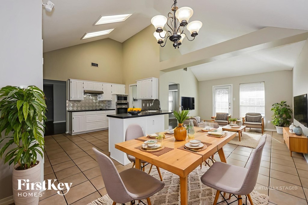 A well-lit kitchen and dining area with a wooden table set for a meal.