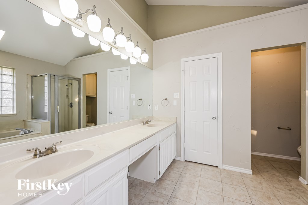 A bathroom with a large mirror and a white sink.