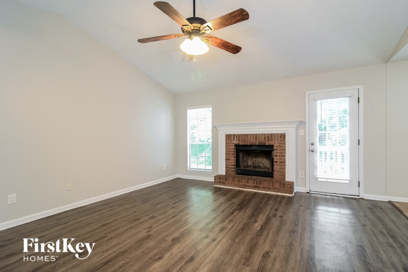 a living room with a fireplace and a ceiling fan